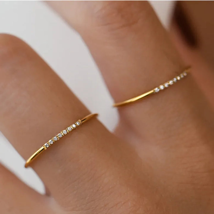 Simple band ring with small zirconias in 18 karat gold-plated titanium
