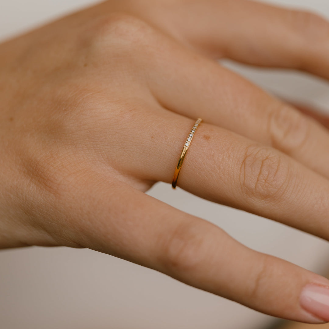 Simple band ring with small zirconias in 18 karat gold-plated titanium