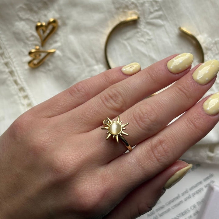 Rotating fidget anti-stress sun ring with white opal in 14 karat gold-plated copper
